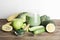 green smoothie in glass, spirulina powder, vegetables and fruits on wooden background.