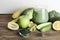 green smoothie in glass, spirulina powder, vegetables and fruits on wooden background.