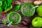 Green smoothie with spinach, apple, ginger and chia seeds on a wooden background. top view