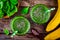 Green smoothie with spinach, banana and chia seeds on a wooden background. top view