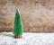 Green snowy Christmas tree decoration on snow with wooden background