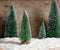 Green snowy Christmas trees decoration and lights on wooden background