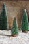 Green snowy Christmas trees decoration and lights on wooden background