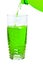 Green soda in a tall glass, pour from the bottle