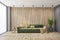 Green sofa in wooden living room with a plant in the corner and big window