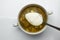 Green Sorrel soup with Boiled meat, and a spoonful of sour cream On a White Table, Horizontal top view from above