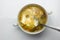 Green Sorrel soup with Boiled meat, and a spoonful of sour cream On a White Table, Horizontal top view from above