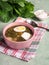 Green soup in a bowl. Sorrel soup with eggs and leaves, onion, bread on a green table.