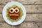 Green spaghetti pasta creative spooky halloween food monster with smile tomato sauce and funny big mozzarella eyeballs