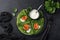 Green spinach crepes with smoked salmon and yogurt sauce on black plate