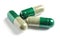 Green spirulina capsules on white background.