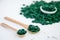 Green spirulina pills in wooden spoons