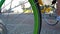 Green spoke wheel of a bicycle with traffic in the background, selected focus