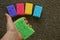 A green sponge in the hand against the background of colored sponges on the floor