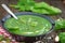 Green spring pureed spinach soup in a bowl decorated with dill