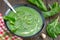 Green spring pureed spinach soup in a bowl decorated with dill