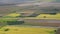 The green squares of the fields cut by ribbons of roads. The view from the window of an oncoming aircraft