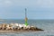 Green starboard lighthouse, with large white stones around. Entrance to the harbor