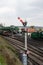 A green steam train next to a train signal