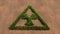 Green summer lawn grass symbol shape on brown soil or earth background, nuclear danger icon
