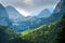 Green sunlit mountain slope in Alps