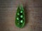 Green sweat pea pod on cutting board.