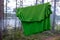 A green synthetic T-shirt is dried on a rope in the forest among the trees.