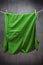 Green t shirt hanging on rope to dry