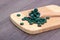 Green tablets - spirulina or chlorella in a wooden spoon. Healthy living concept