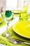 Green tableware and cutlery and white tablecloth set at an outdo