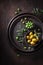 Green and tasty olives in bowl with an olive branch