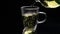 Green tea is being poured from the glass teapot ona black background