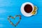 Green tea with heart shape over blue background. top view with teacup