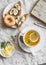 Green tea with lemon and thyme, banana sandwich with chia seeds, donuts on a light background, top view. Afternoon tea. Vintage st