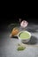 Green tea matcha latte with bamboo chasen and bamboo spoon in a bowl on gray marble with beautiful oleander flowers. Japanese tea