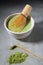 Green tea matcha latte with bamboo chasen and bamboo spoon in a bowl on gray marble. Japanese tea ceremony concept