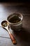 Green tea sencha in a traditional, japanese tea cup and sencha leaves on a wooden tea spoon.