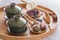 Green tea and tea ceremony attributes - ceramic teapot, cups, strainer, chopsticks and tweezers placed