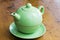 Green teapot on a wooden kitchen surface