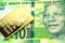 A green ten rand note from South Africa with a gold coin in macro