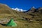 Green tent in an empty camping at the bottom of beautiful snow mountain