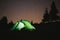 Green tent light in forest outdoor at night