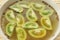 Green tomato in bowl with vinegar and spice