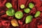 Green tomatoes ripen on a red fabric. group of green tomatoes on top of a fabric