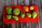 Green tomatoes ripen on a red fabric. group of green tomatoes on top of a fabric