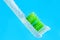 Green toothbrush in bubbles of air on blue