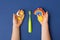 Green Toothbrush and kid hands with decorative Sun, rainbow, moon and stars on classic blue background. Care about teeth in