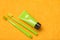 Green toothbrushes with paste tube on yellow bath towel. Visual representation for dental clinics