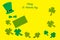 Green top hat, clover leaves, shamrocks on yellow background
