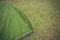 Green touristic tent among grass , on grassland, forest camp